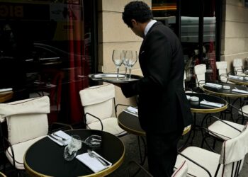 Un cameriere tra i tavoli all'aperto di un ristornate (Foto Pexels di Yelenaodintsova )