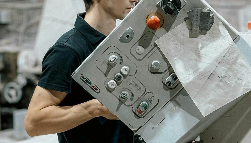 Un tecnico alle prese con i macchinari all'interno di un azienda (foto pexels bulat)