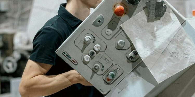 Un tecnico alle prese con i macchinari all'interno di un azienda (foto pexels bulat)